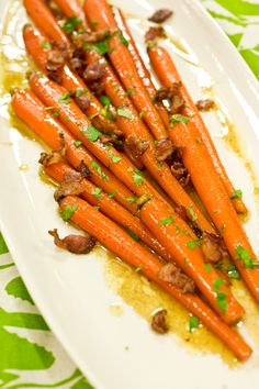 carrots are arranged on a white plate and garnished with parsley