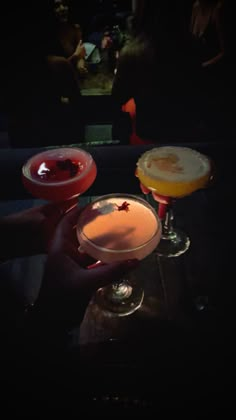 three cocktails sitting on top of a table next to each other