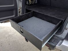 the back end of a truck with an open drawer in it's trunk area