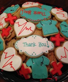 decorated cookies in the shape of doctors and nurse's shirts with thank you written on them