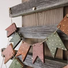 some wooden stars hanging from a string on a wall