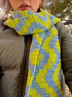 a woman wearing a green and blue knitted scarf