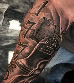 a man's arm with a black and grey tattoo on it, including an old fashioned