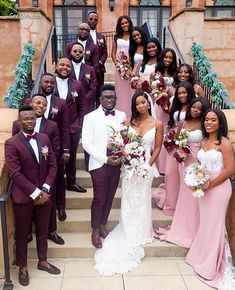 a group of people in formal wear posing for a photo on some steps with flowers