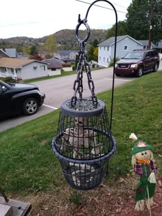 a birdcage with stuffed animals in it sitting on the grass next to a street