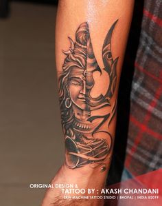 a tattoo on the arm of a man with a buddha head and an arrow in it