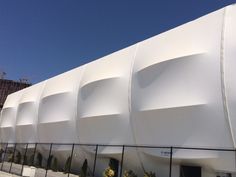 a large white building sitting next to a fence