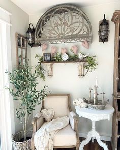 a chair and table in a room with some plants on the shelf above it, along with other items