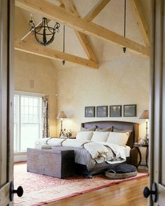 a large bed sitting inside of a bedroom on top of a hard wood floor