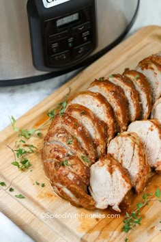 sliced pork on a cutting board next to an instant pressure cooker