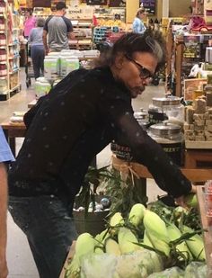 a man standing in front of a table filled with vegetables