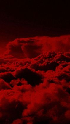 the sky is full of clouds and red light from above it, as seen from an airplane