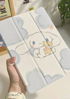 a person holding up an ipad case with cartoon drawings on the front and back cover