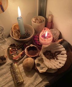 an assortment of seashells and candles on a table