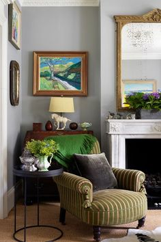 a living room filled with furniture and a fire place next to a painting on the wall