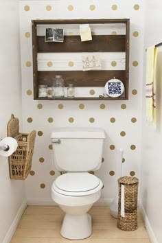 a white toilet sitting in a bathroom next to a wooden shelf filled with pictures and other items