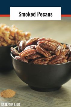 two bowls filled with pecans on top of a wooden table