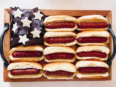 a wooden tray filled with hot dogs and tortilla chips