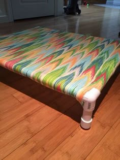 a colorful bench sitting on top of a hard wood floor