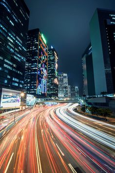 the city is busy with cars and lights at night, as well as skyscrapers