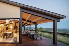 an outdoor dining area with wooden flooring and large sliding glass doors to the outside