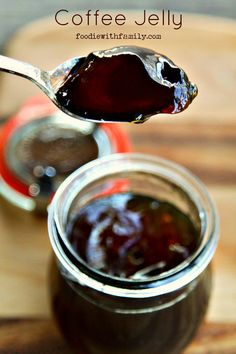 a spoon full of jam sitting on top of a wooden table