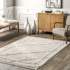 a living room scene with focus on the rug and chair, vases and sideboard