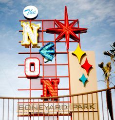 the neon motel sign is on display in front of a fence