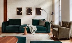 a living room filled with green couches and chairs next to a white brick wall