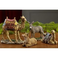 three figurines of camels and horses on a table