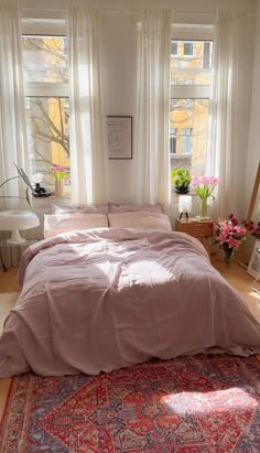 a bed sitting in a bedroom next to two windows and a rug on the floor