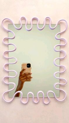 a woman taking a selfie in front of a mirror with pink spirals on it