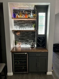 a wine rack in the corner of a kitchen next to a counter with bottles on it