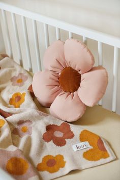 a baby's crib with a pink flower on it