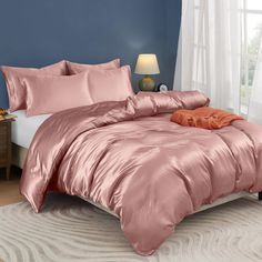 a bed in a bedroom with pink comforter and pillows