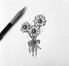 a drawing of some flowers on a sheet of paper with a pen next to it