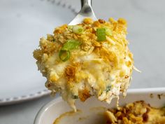 a close up of a spoon with food in it on a white plate next to a fork