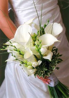 a bride holding a bouquet of white flowers