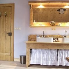 a bathroom with two sinks and wooden cabinets