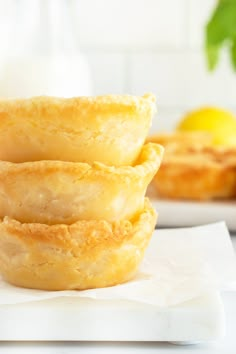 three lemon filled pastries stacked on top of each other in front of some lemons