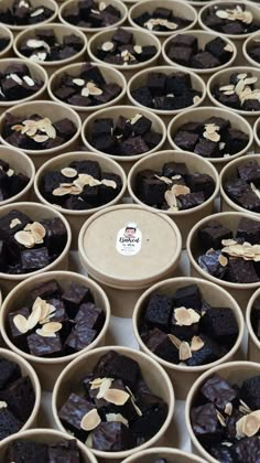 several cups filled with brownies and nuts on top of a table next to each other