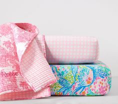 three bath towels stacked on top of each other in different colors and patterns, with one folded up to the side