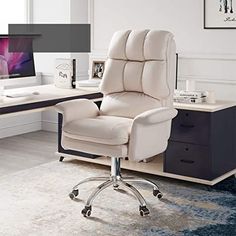 a white office chair sitting in front of a desk with a computer monitor on it