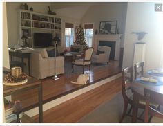 a living room filled with furniture and a fire place next to a dining room table