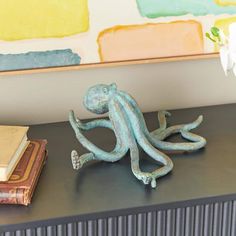 an octopus figurine sitting on top of a black table next to a book