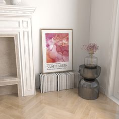 there is a vase with flowers in it next to two books on the floor near a fireplace