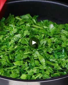 a pot filled with green leafy vegetables on top of a stove