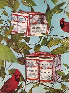 two cans of budweiser sitting on top of a tree with birds in the background