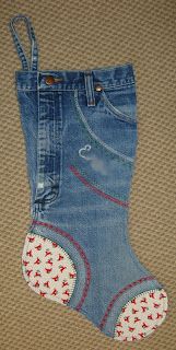 a pair of blue jeans with red and white flowers on them, hanging from the side