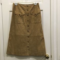 Ralph Lauren Black Label Classic Tan Suede A Line Skirt Size 8 9 Buttons Used To Close Front Of Skirt 2 Large Pockets With Buttoned Flaps In Upper Front Skirt 15 1/2” Waist 20” Hips 29” Length From A Smoke Free And Dog Loving Home Indented Small Area From Plastic Hanger Near Waist, Otherwise In Excellent Condition, Never Worn. Belts Cover It, Cleaners Can Try Steaming, Maybe In Time It Will Disappear, Hope So! Use The Two Tie Loops Provided To Prevent Future Pressure Fitted Brown Maxi Skirt For Workwear, Fitted Long Skirt With Button Closure, Brown Fitted Full Length Skirt, Full Length Brown Relaxed Fit Skirt, Brown Full Length Skirt, Tan Suede Skirt, Ralph Lauren Black Label, Plastic Hangers, Suede Skirt